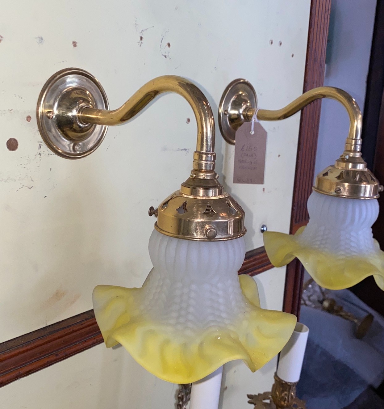A pair of 1930s French lacquered brass wall lights with yellow tinted quilted and frosted glass shades, height 19cm